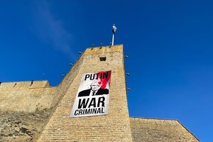 Estija: gegužės 9-ąją ant Narvos pilies sienos atsirado plakatas su užrašu „Putinas – karo nusikaltėlis“