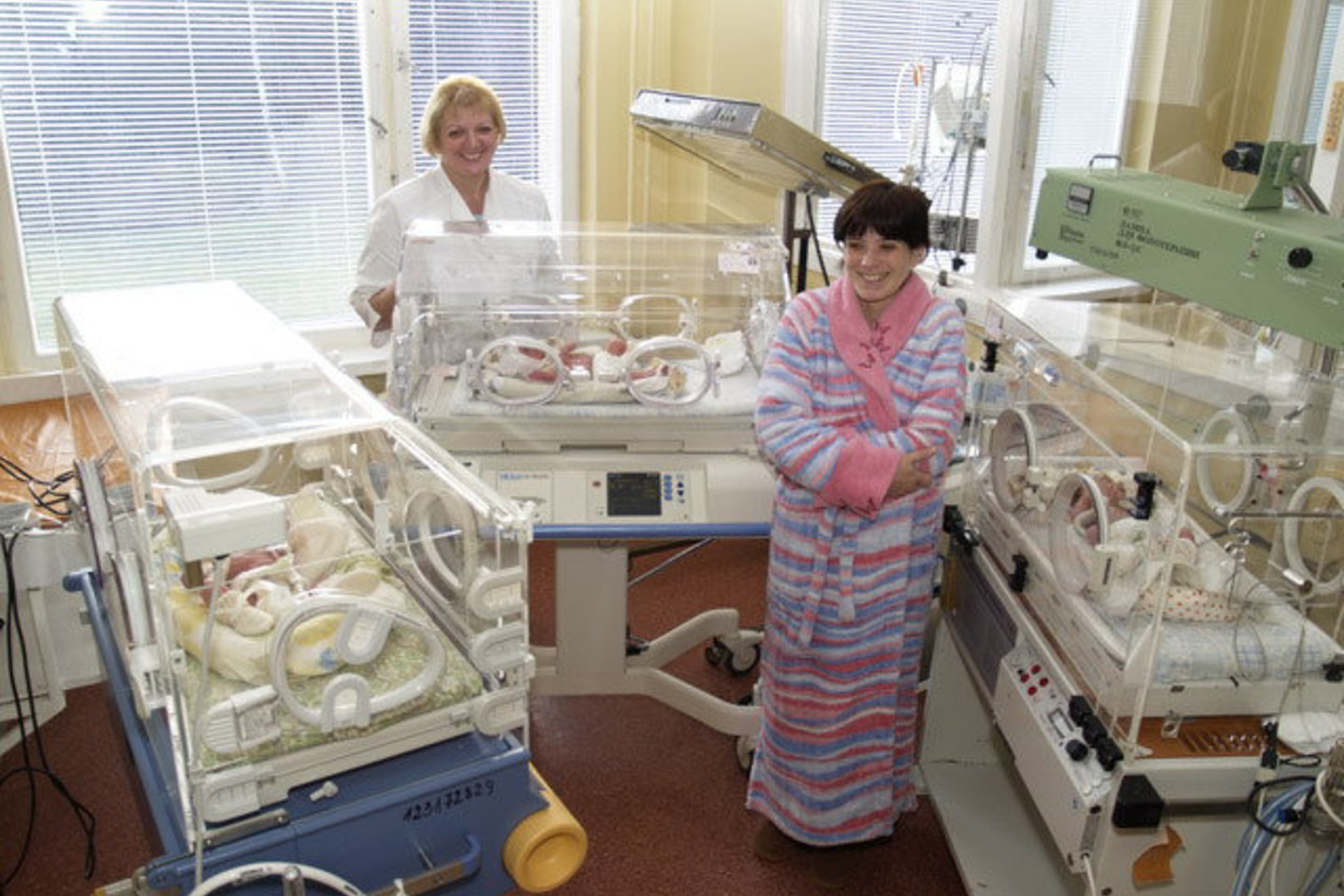 Gydytojos A.Bulaukienės (kairėje) prižiūrimas tris mergaites jų motina R.Petrulienė kol kas gali matyti tik pro inkubatoriaus stiklą.