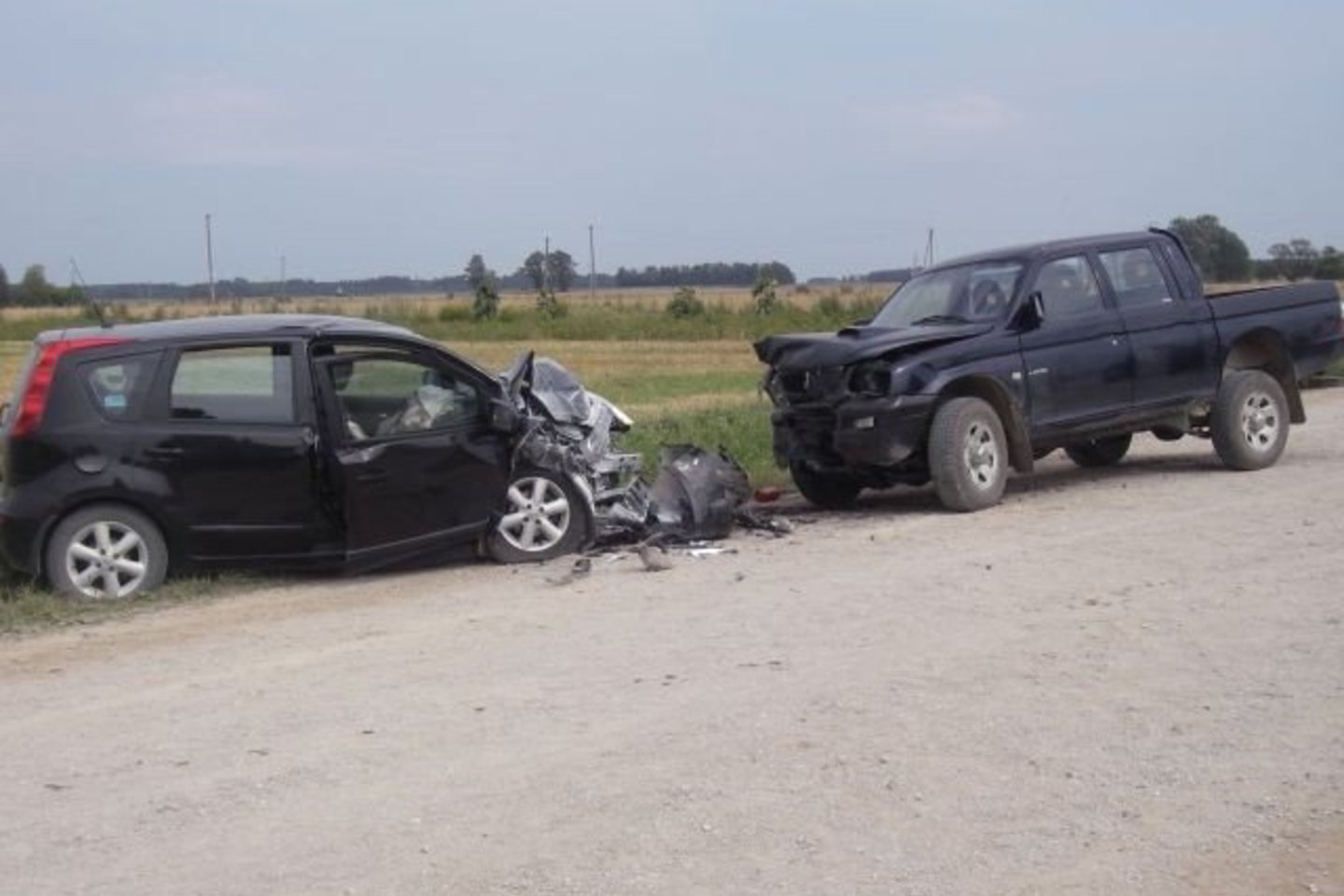 Lengvasis automobilis ir visureigis dulkėtame žvyrkelyje trenkėsi kaktomuša.