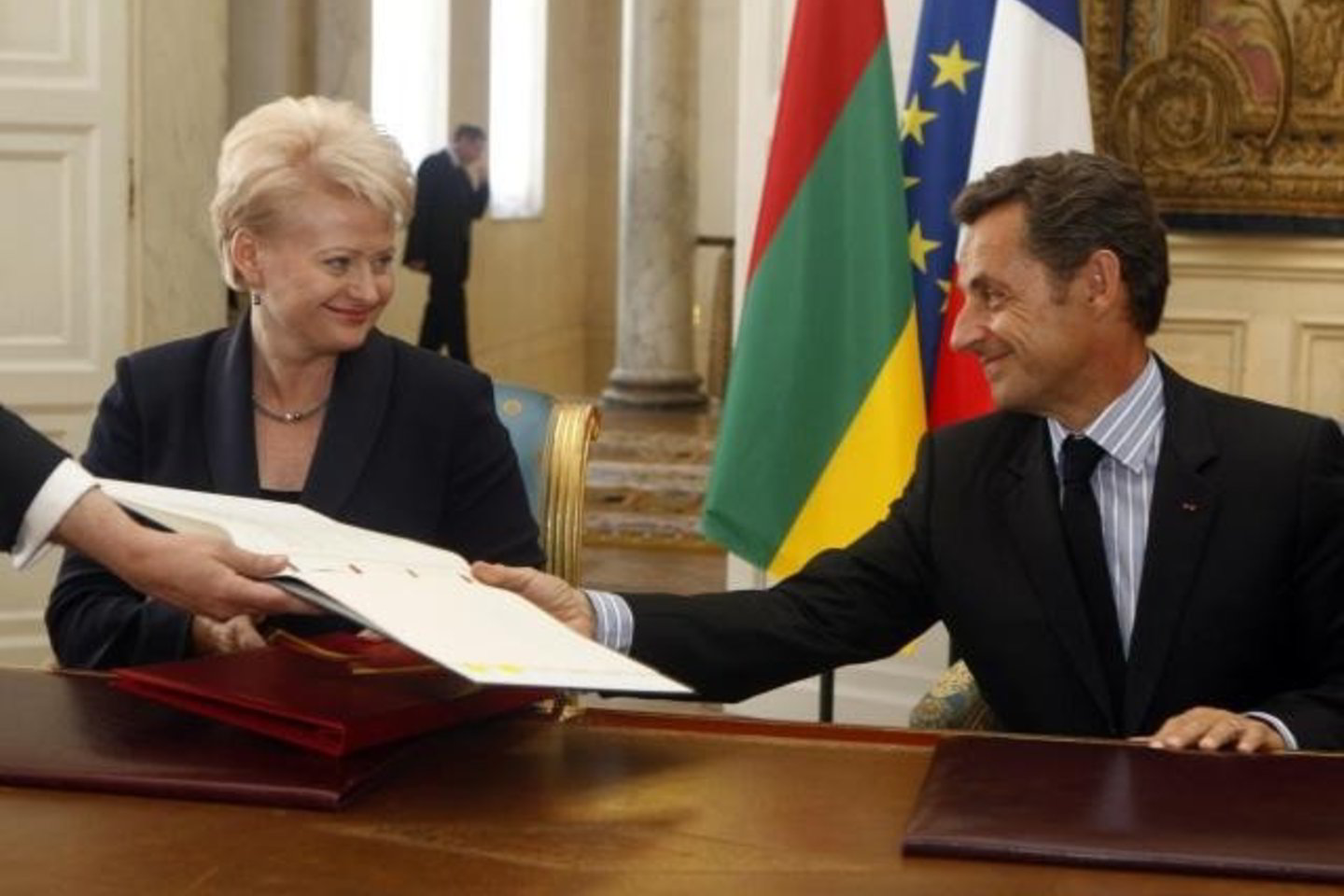 D.Grybauskaitė ir N.Sarkozy meiliai šypsosi vienas kitam. Vaizdą gadina tik atvirkščiai pakabinta trispalvė.