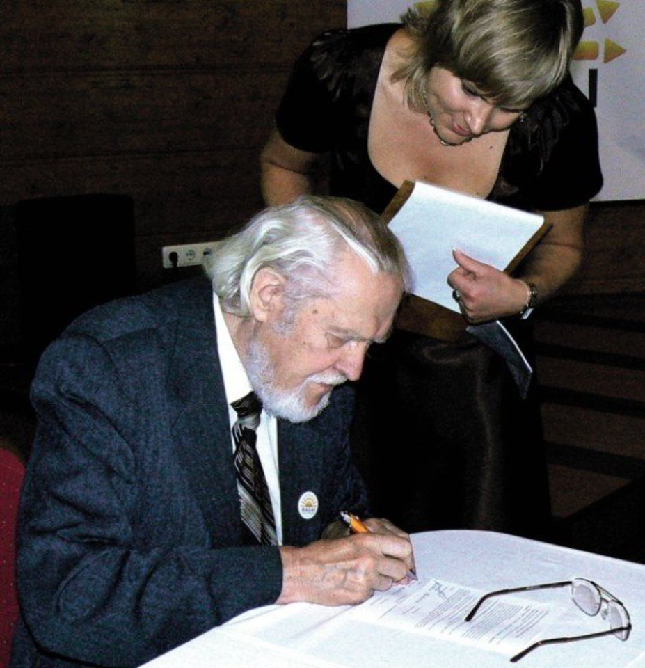 Sutartį su Raseinių krašto ateities sąjūdžio steigėjais pasirašo Raseinių r. garbės pilietis, poetas Marcelijus Martinaitis. Šalia – Raseinių krašto ateities sąjūdžio „RASAI“ viena kūrėjų Kristina Bartkutė.