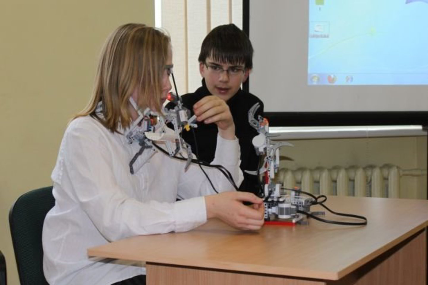 Komandos nariai Mykolas Kavaliauskas ir Justas Jasevičius demonstruoja roboto ranką, valdomą veido judesiais.