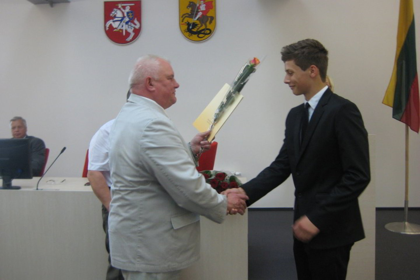 Marijampolės meras V.Brazys spaudžia ranką Rygiškių Jono gimnazijos auklėtiniui M.Brusokui, gavusiam keturis šimtukus.