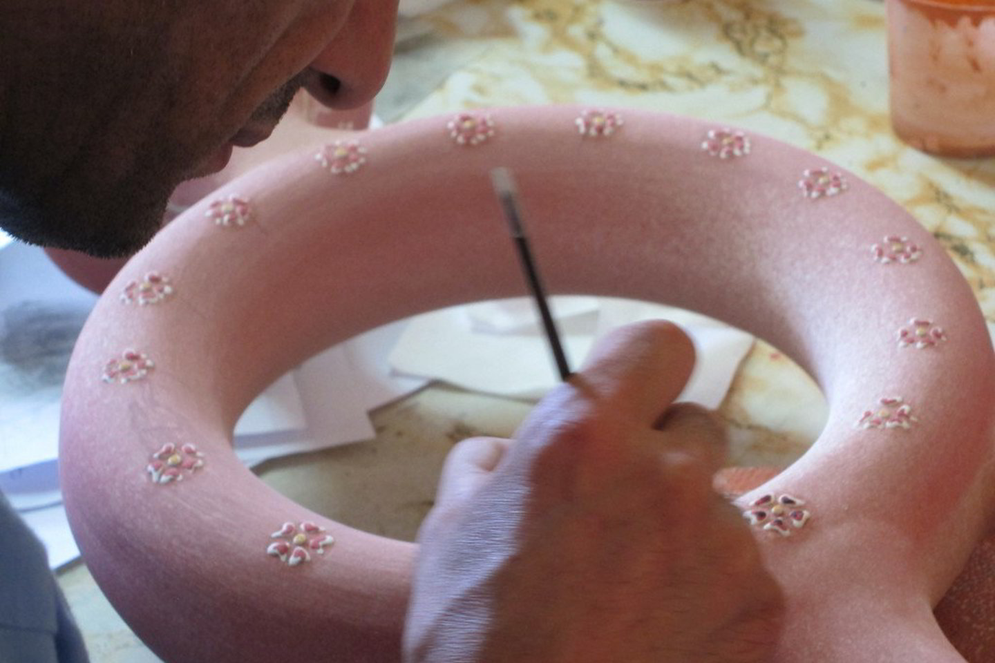 Ant peties dedama unikalios formos vaza pirmiausia padengiama specialia glazūra, kuri sudaro reljefiškus raštus. Vėliau jie bus spalvinami.