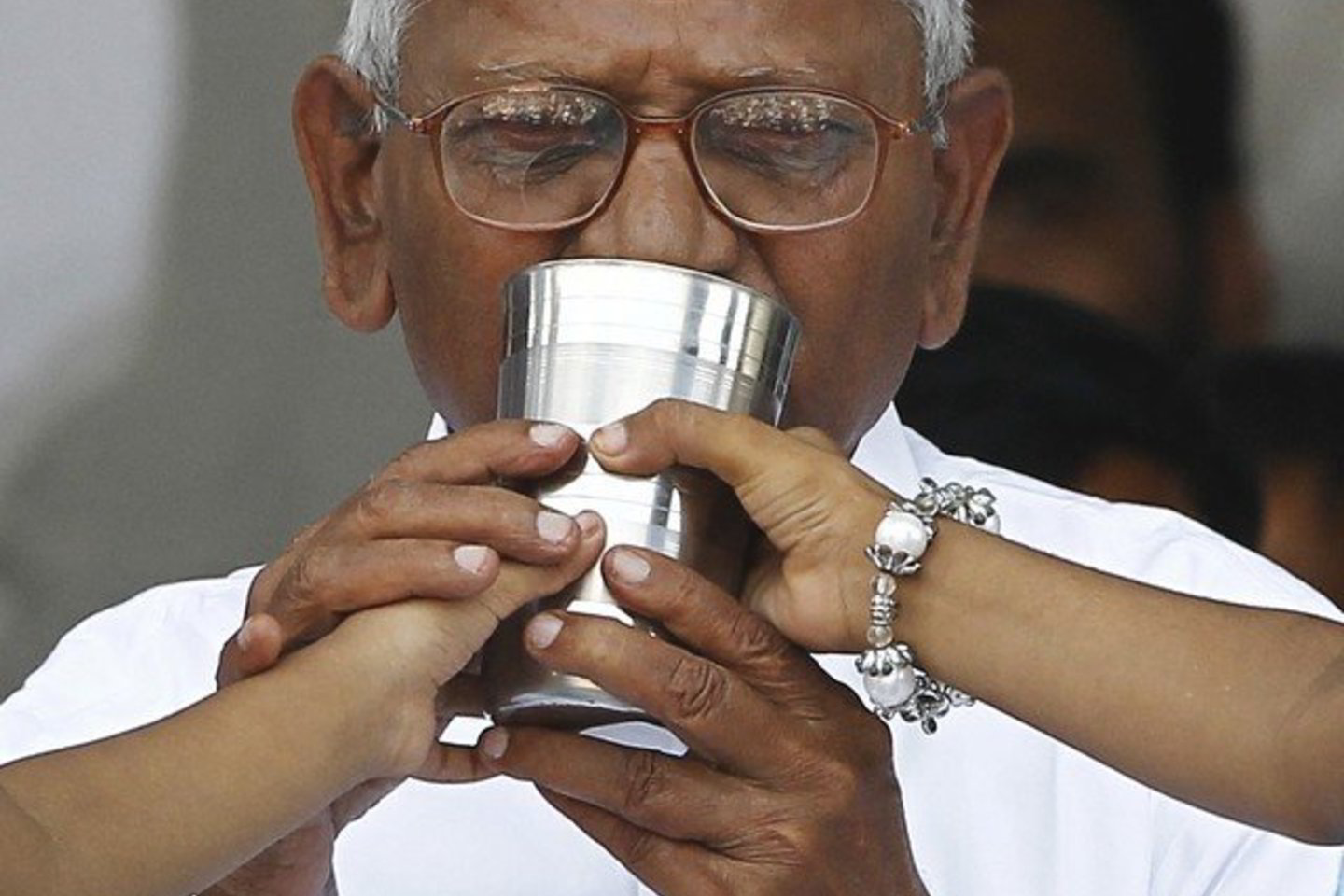 A.Hazare iš penkiametės mergaitės paėmė stiklinę sulčių.