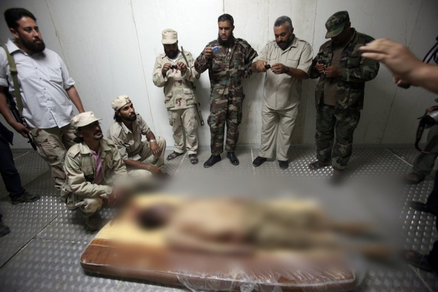 Buvusio Libijos lyderio Muamaro Gaddafi lavonas prienamas apžiūrėti vienoje iš produktų šaldyklų.