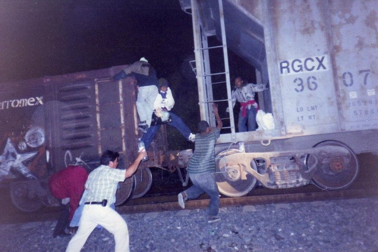 Migrantai bando įšokti į riedantį traukinį.