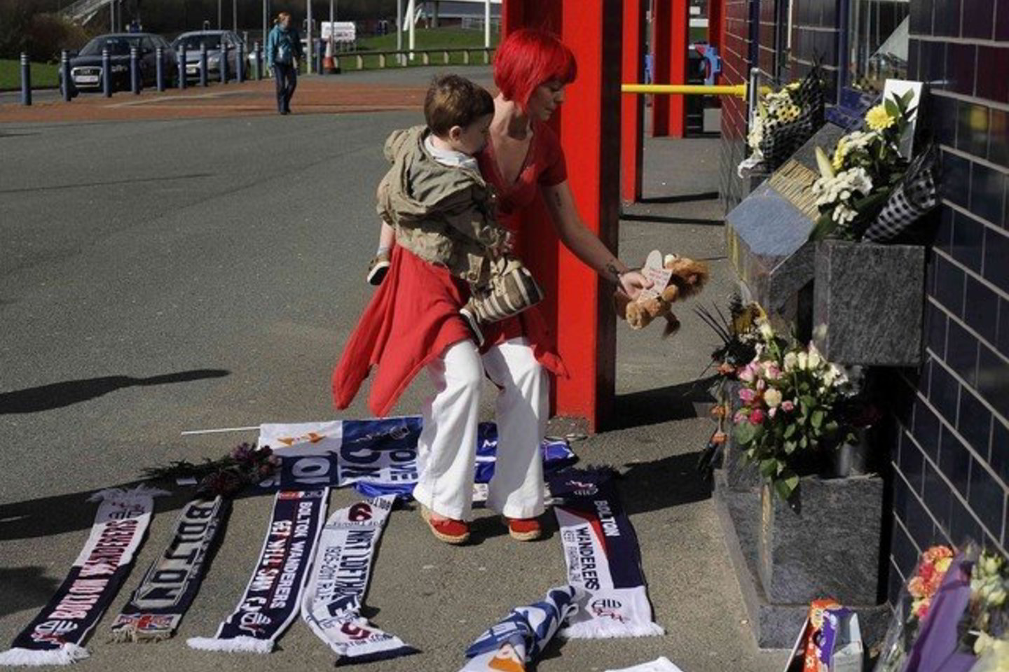 Prie "Bolton Wanderers" futbolo stadiono gerbėjai neša glėbius gėlių, šalikus ir palieka žinutes.