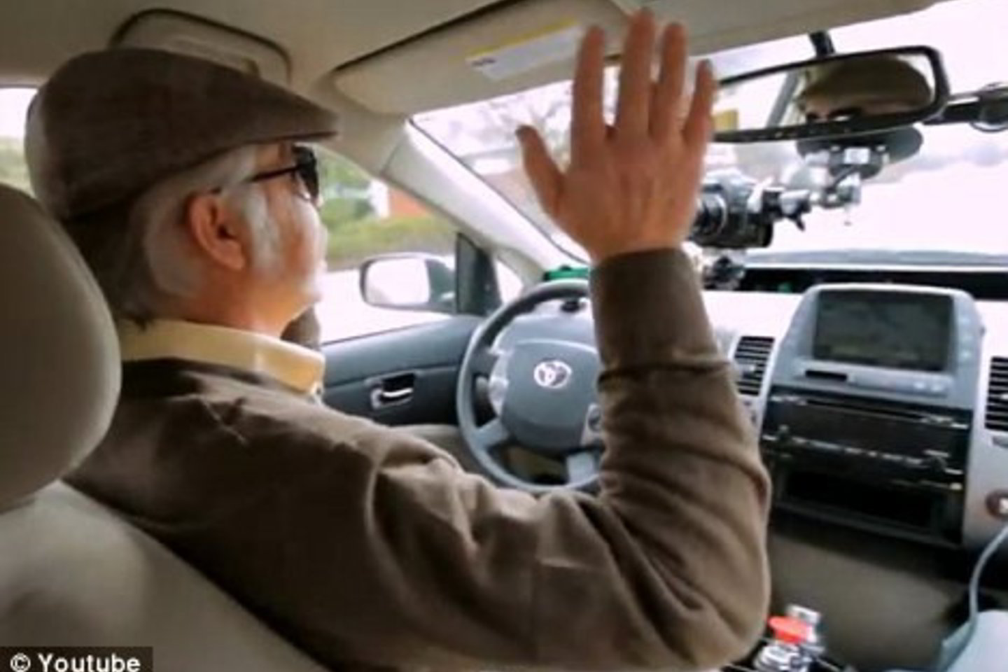 Aklas žmogus prie automobilio - roboto vairo.