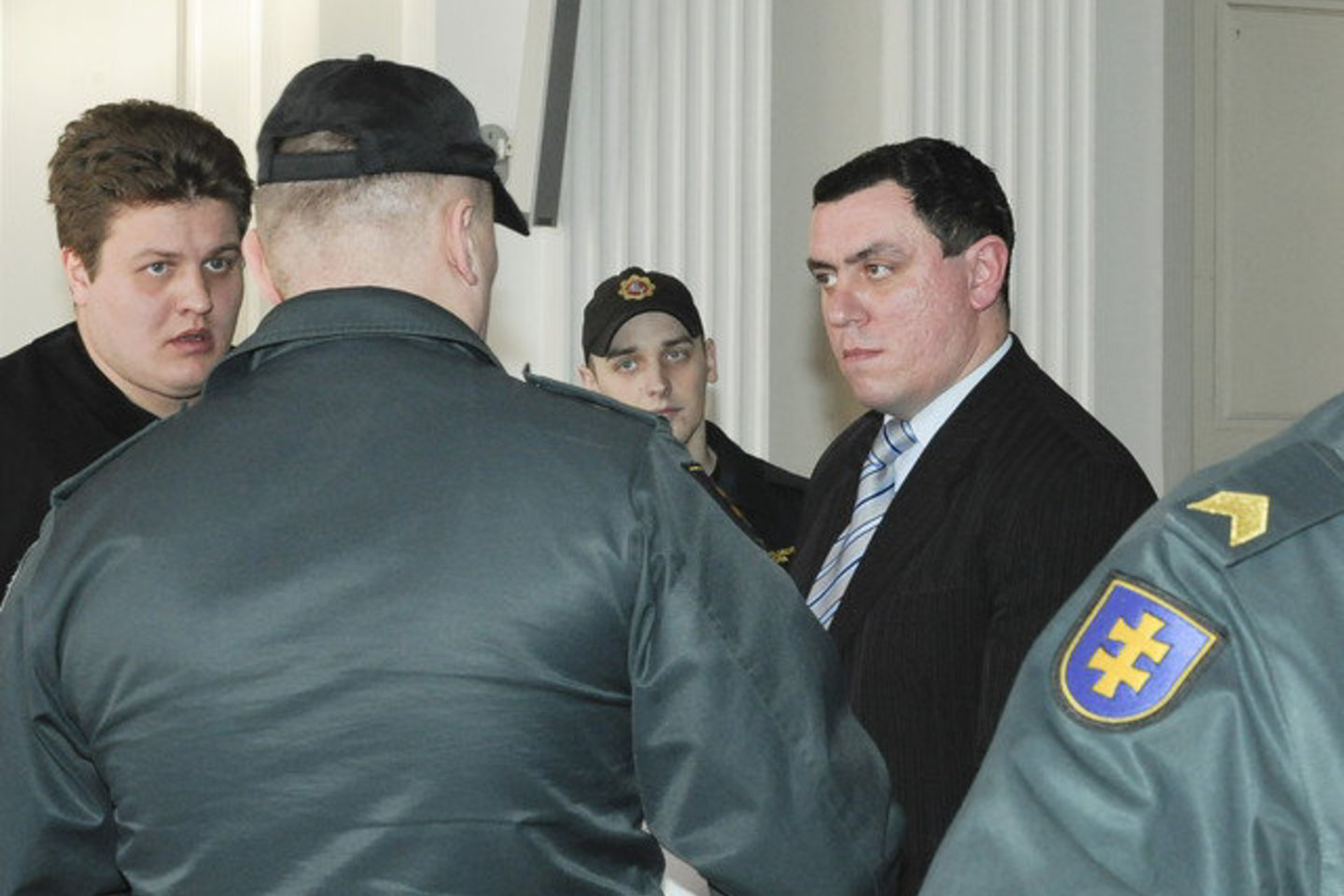 Mažametės prievartautojas M. Bisikirskis (tarp policininkų) pernai vasarį buvo suimtas teismo salėje.
