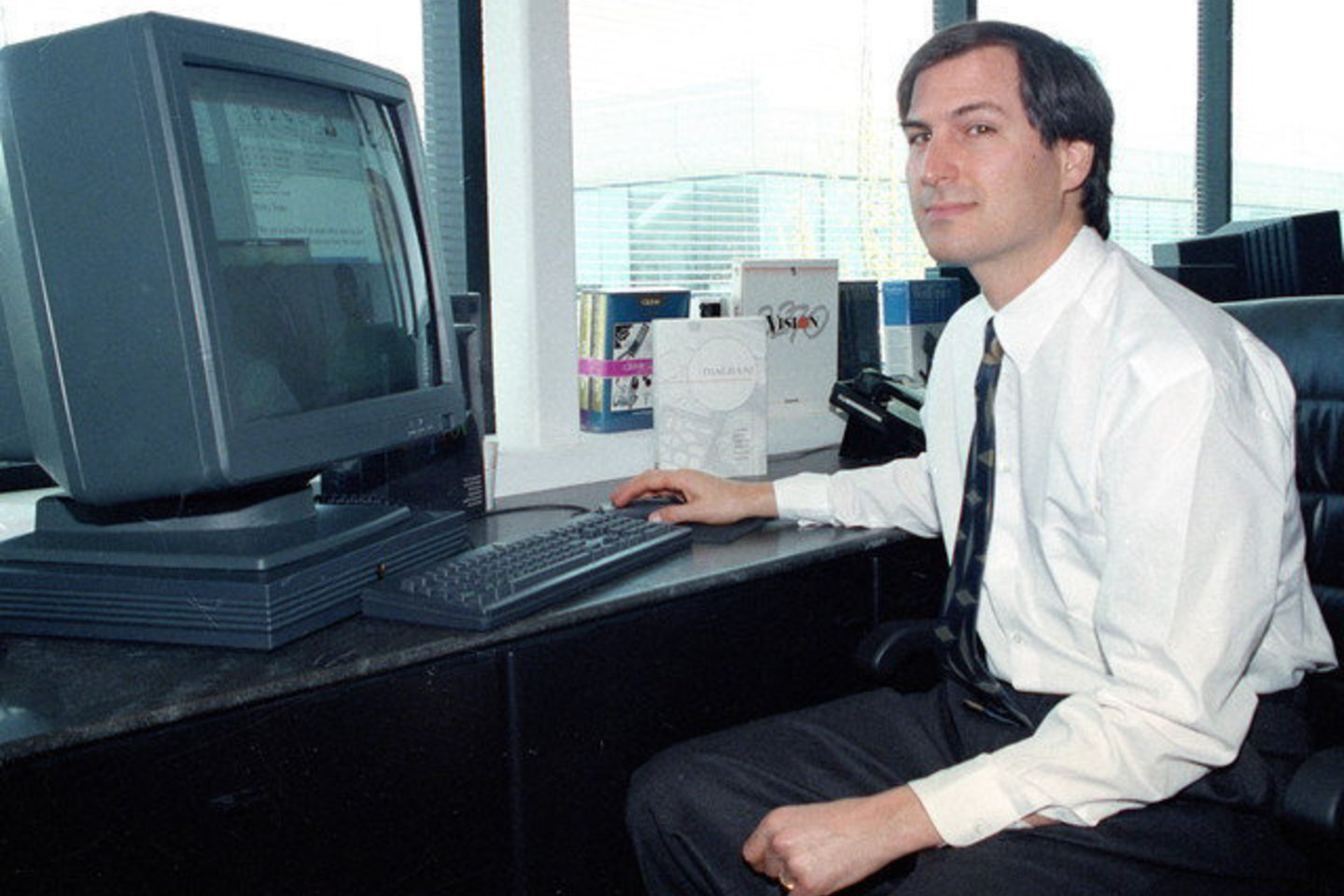 Steve'as Jobsas 1991 metais. Nuotraukoje technologijų kūrėjas pozuoja prie "NeXTstation" kompiuterio.