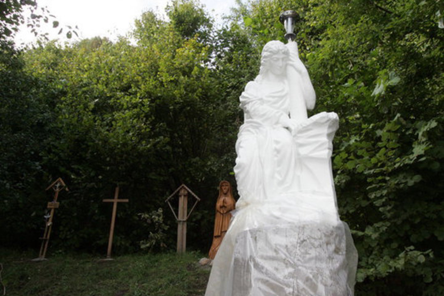 D. Kedžio radimo vietoje pastatytas baltas angelas, keli kryžiai ir medinė skultūra.