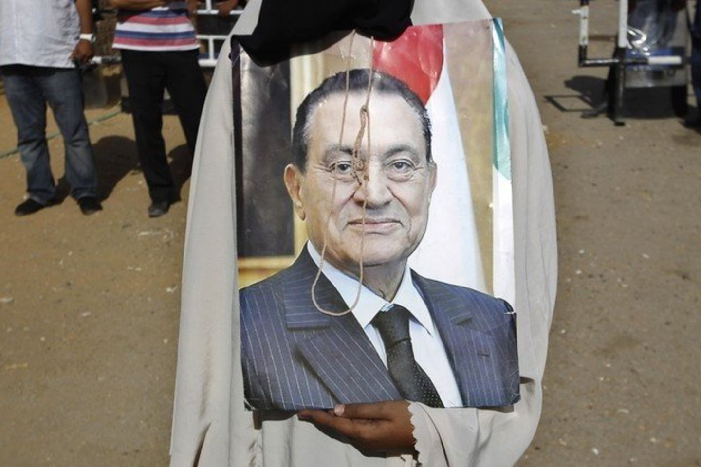 Buvusio Egipto vadovo H. Mubarako sekėjas laiko jo portretą.