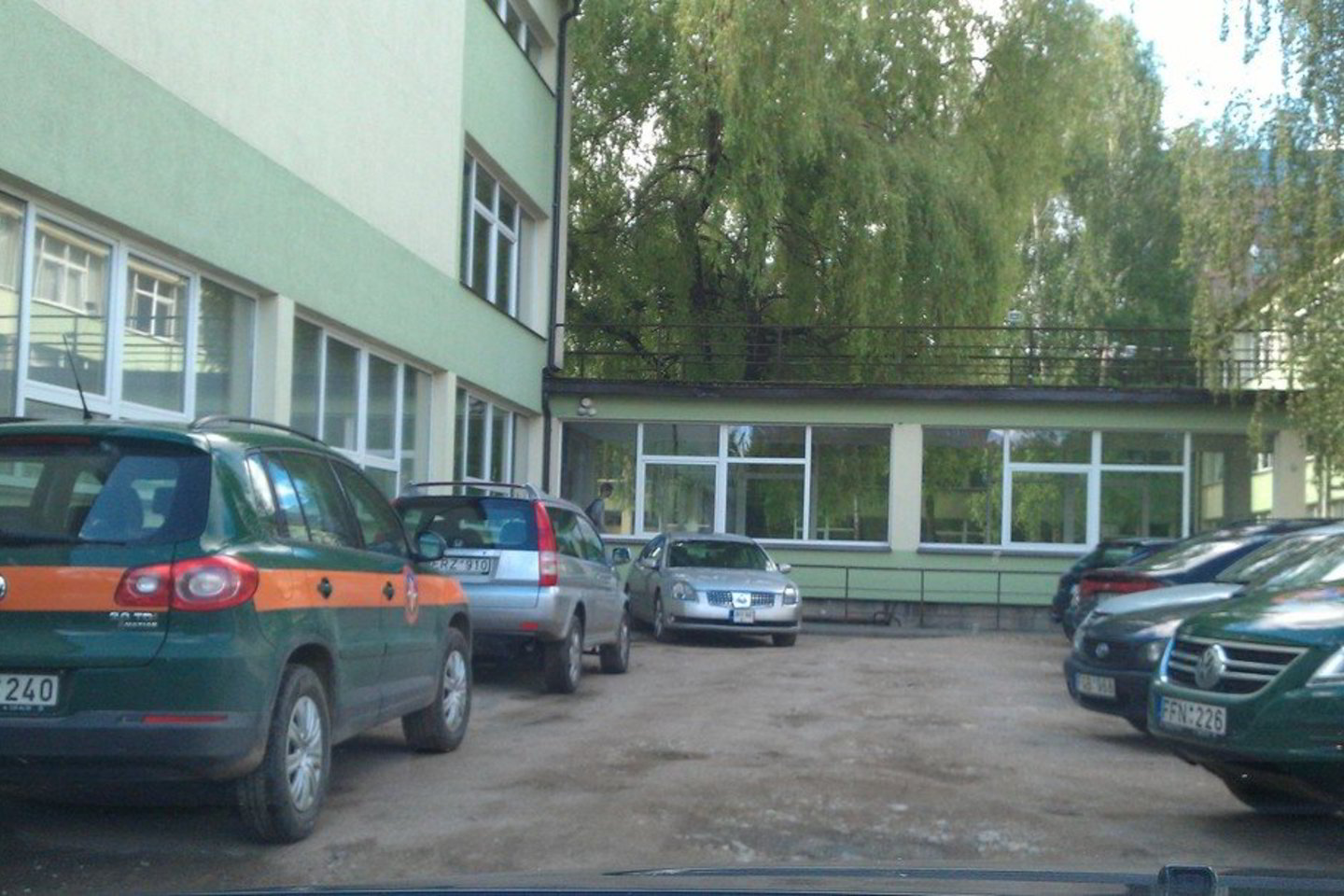 „Santaros“ vidurinės mokyklos kieme akis bado automobiliai, pažymėti ženklu „Lietuvos aplinkos apsauga“.