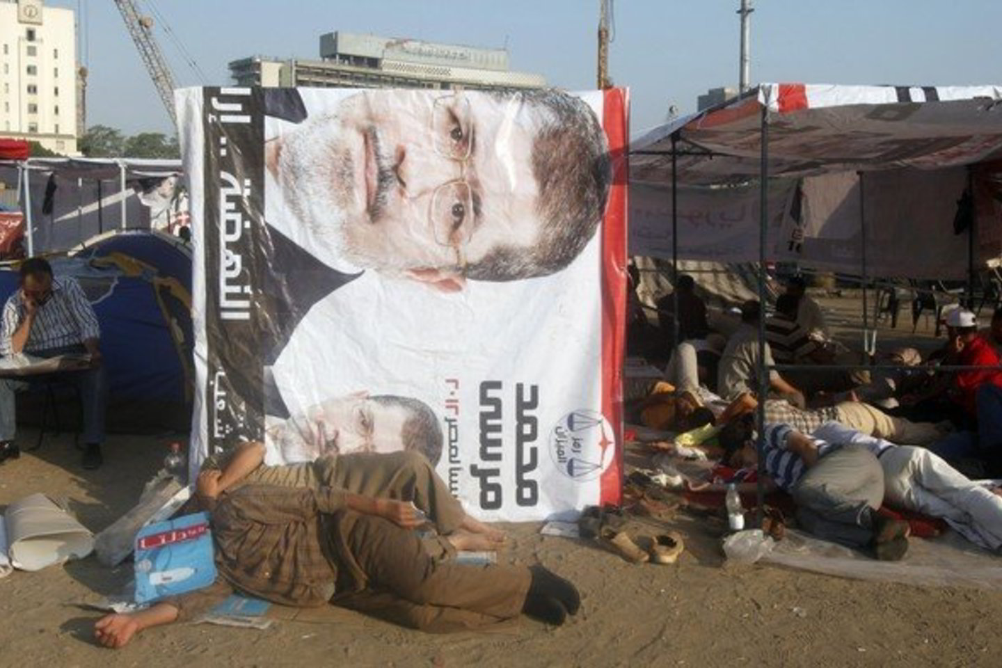 Protestuotojai miega prie kandidato į prezidentus Mohamedo Mursi plakato.