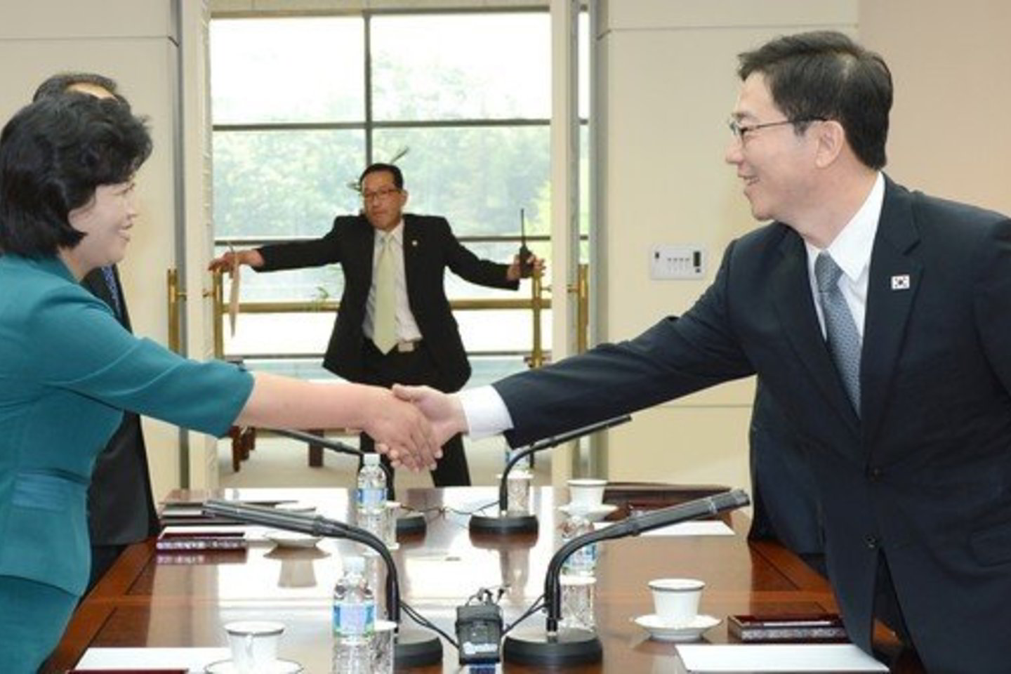 Pietų Korėjos atstovas Chun Hae-sung (dešinėje) spaudžia ranką Šiaurės Korėjos atstovei Kim Song-hye.