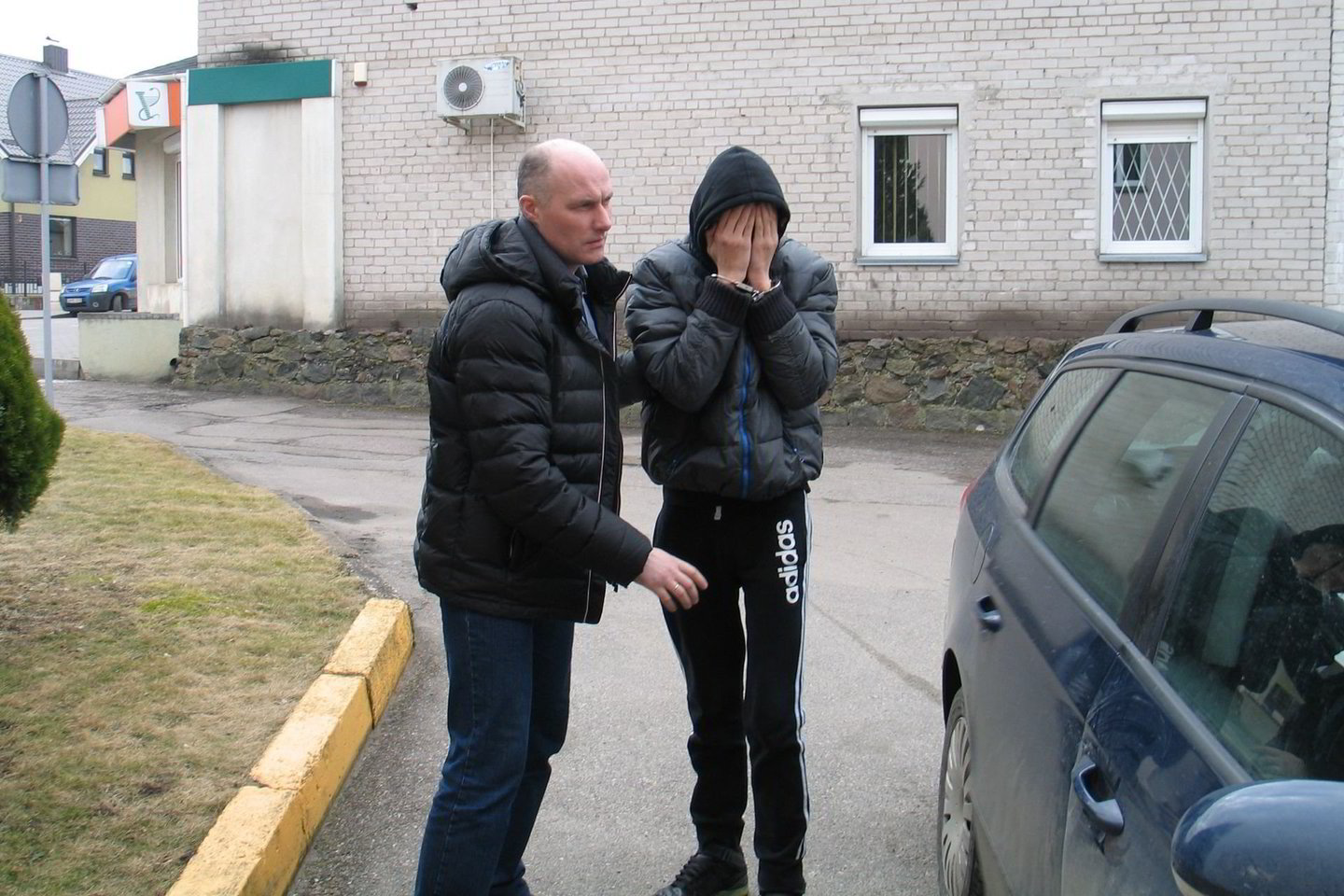 Į teismą vedamas nepilnametis slėpė veidą.