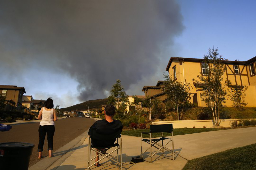 Ugniagesiai dirba svilinančiame karštyje, o amerikiečiai, į kurių būstus kėsinasi liepsna, priversti palikti savo namus.<br>AP nuotr.