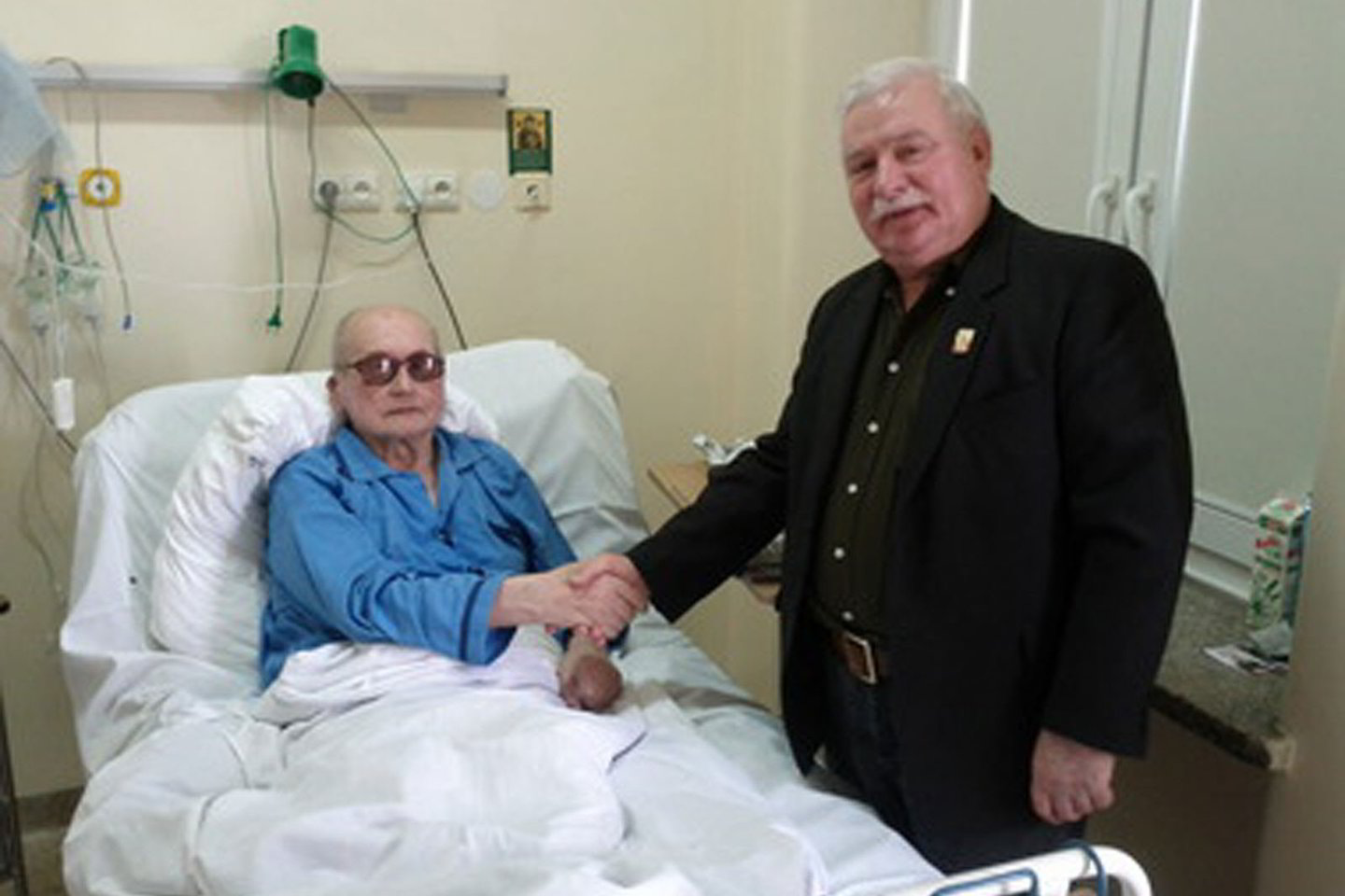 Sunkiai sergantis W.Jaruzelskis spaudžia ranką savo priešininkui L.Walensai. 2011 metai.