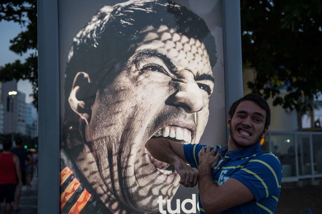 Žmonės pozuoja prie L.Suarezo nuotraukos.<br>AFP/Scanpix nuotr.