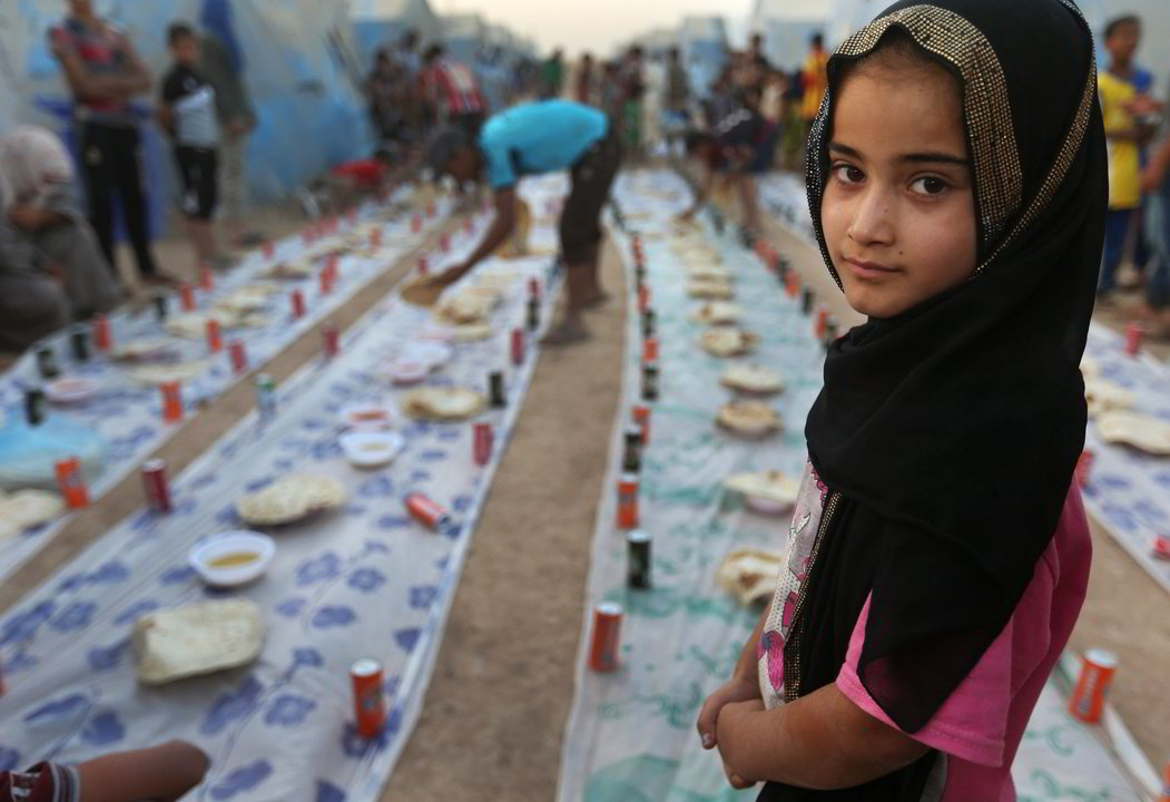 Mergaitė Irake laukia, kol nusileis saulė ir kartu su kitais tikinčiaisiais susės bendram valgiui.<br>AP nuotr.