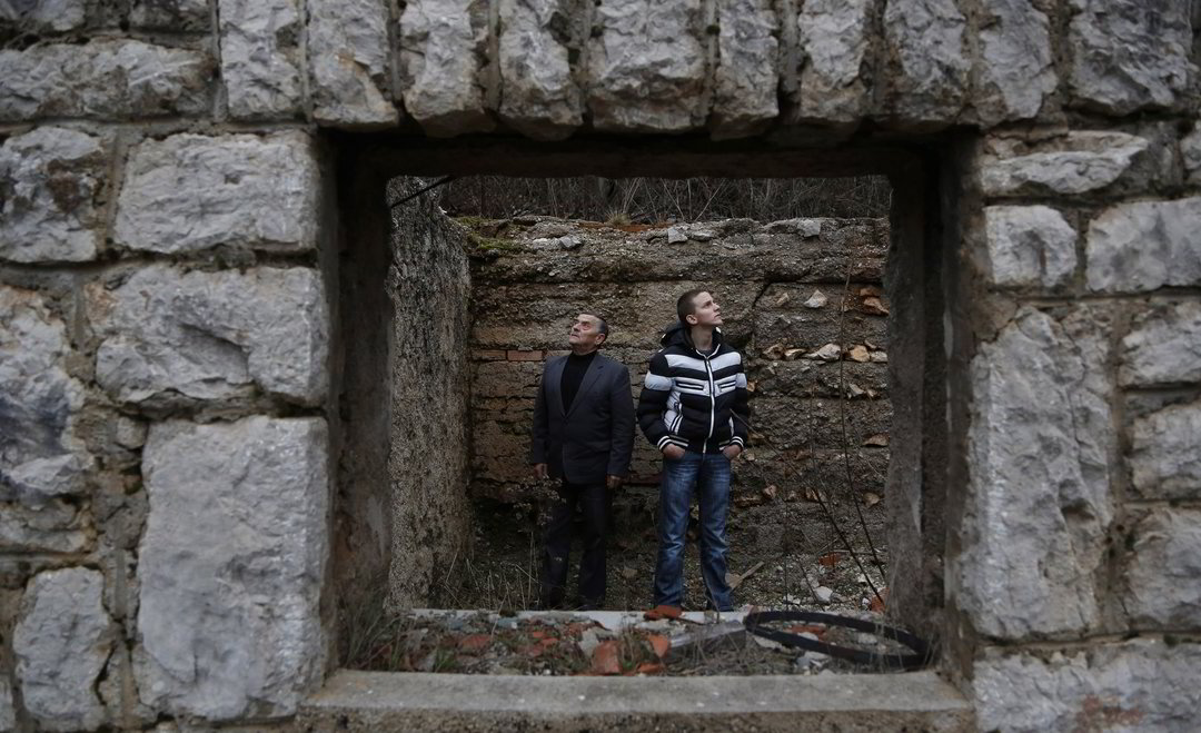 Nikolas Principas (kairėje) kartu su savo anūku Novaku Principu apžiūrinėja dėdės Gavrilo Principo gimtojo namo griuvėsius.<br>AP nuotr.