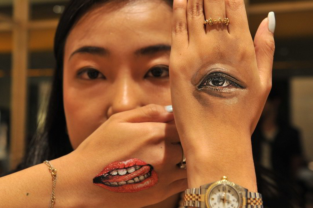 Japonų kūno dailininkė Hikaru Cho ant vieno moters plaštakos nupiešė jos pačios akį, o ant kitos - burną.<br>„Scanpix“ (AFP) nuotr.