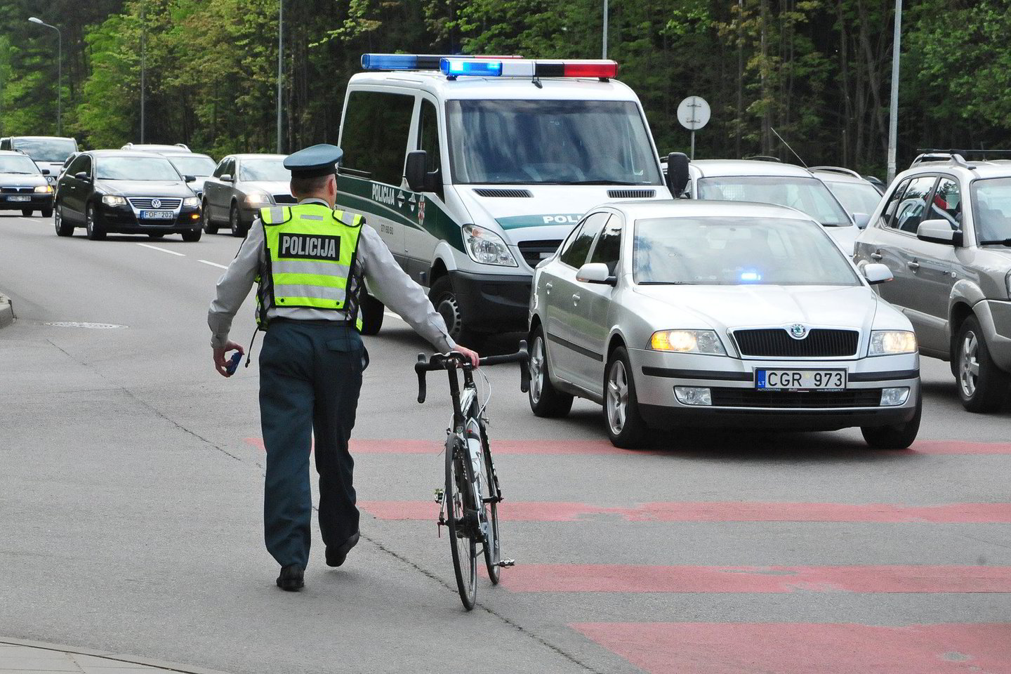 Policijos pareigūnas varo dviratį po eismo įvykio<br>Andriaus Vaitkevičiaus nuotr.