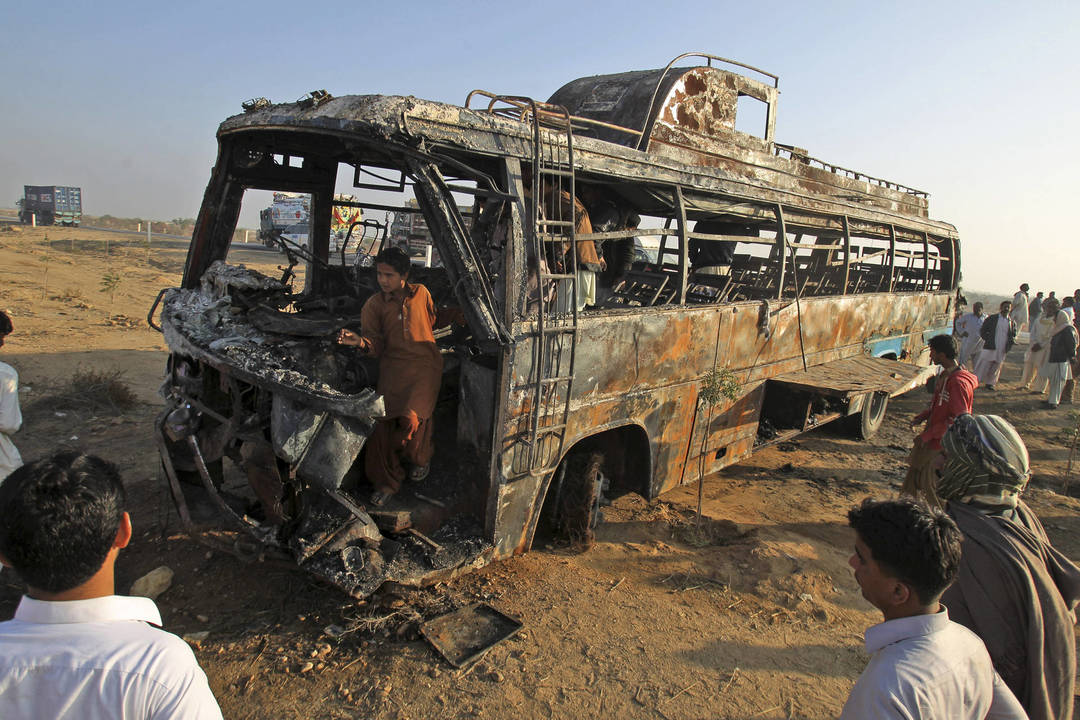 Sekmadienį Pakistane prie Karačio kaktomuša susidūrus keleiviniam autobusui ir benzinvežiui, žuvo mažiausiai 57 žmonės.<br>AP nuotr.