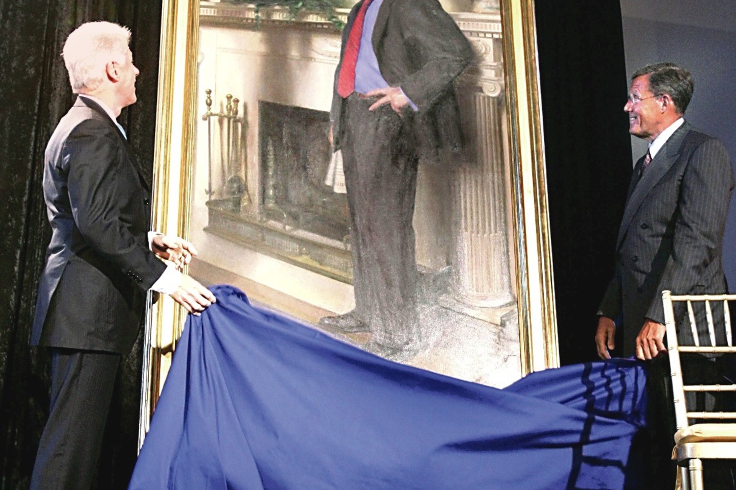 B.Clintono portrete – ir jo meilužės M.Lewinsky suknelės šešėlis ant židinio.