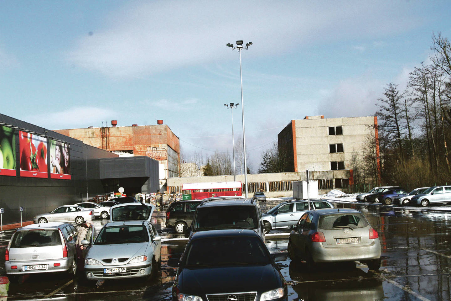 Iš šonų naująjį prekybos centrą supa seniai apleisti daugiaaukščiai statiniai.
