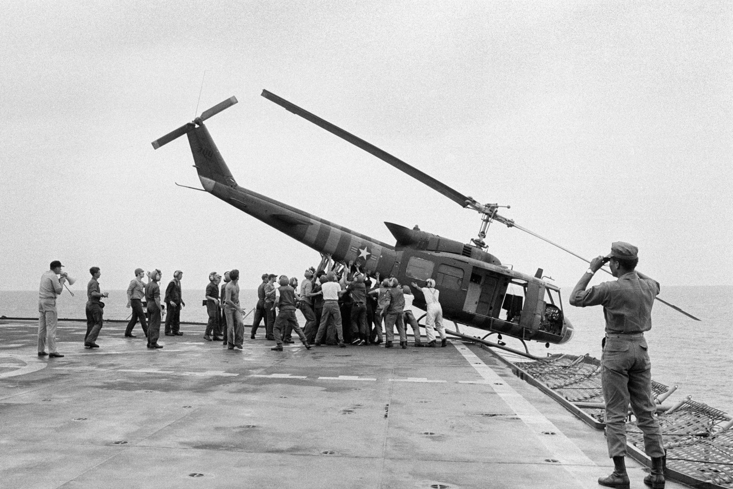 1975 metai. JAV kariai nuo laivo „USS Blue Ridge“ nustūmė sraigtasparnį, kad ant borto būtų daugiau erdvės pabėgėlius atgabenantiems skrydžiams.