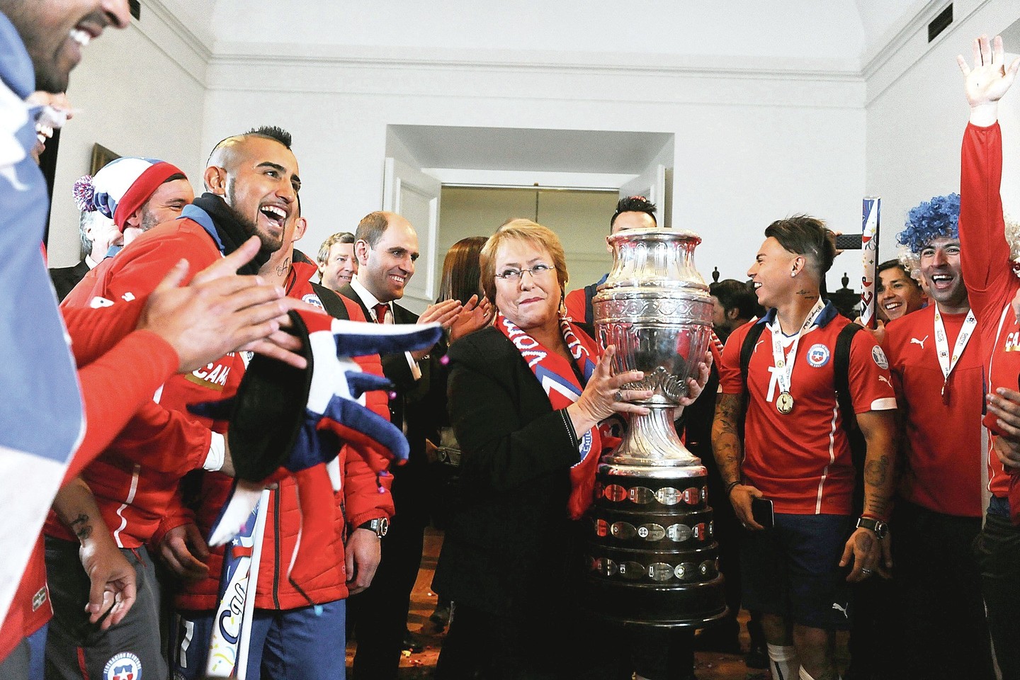 Čilės futbolininkai taure džiaugėsi su šalies prezidente M.Bachelet.<br>AP nuotr.