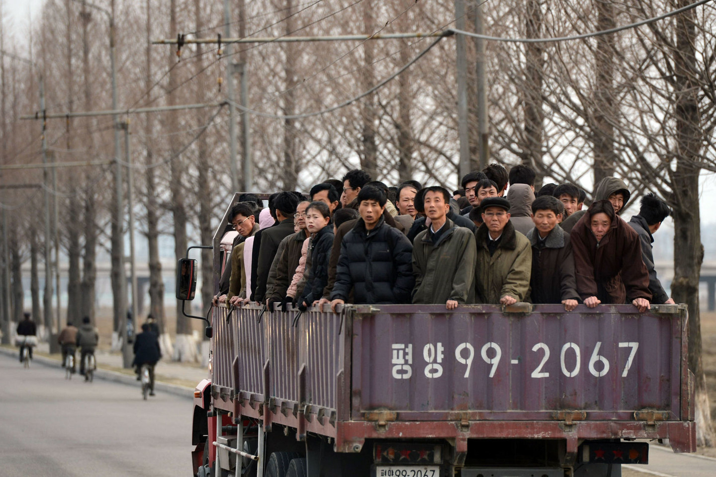 Šiaurės Korėjos darbininkai važiuoja į darbą.<br>AFP/ „Scanpix“ asociatyvioji nuotr.