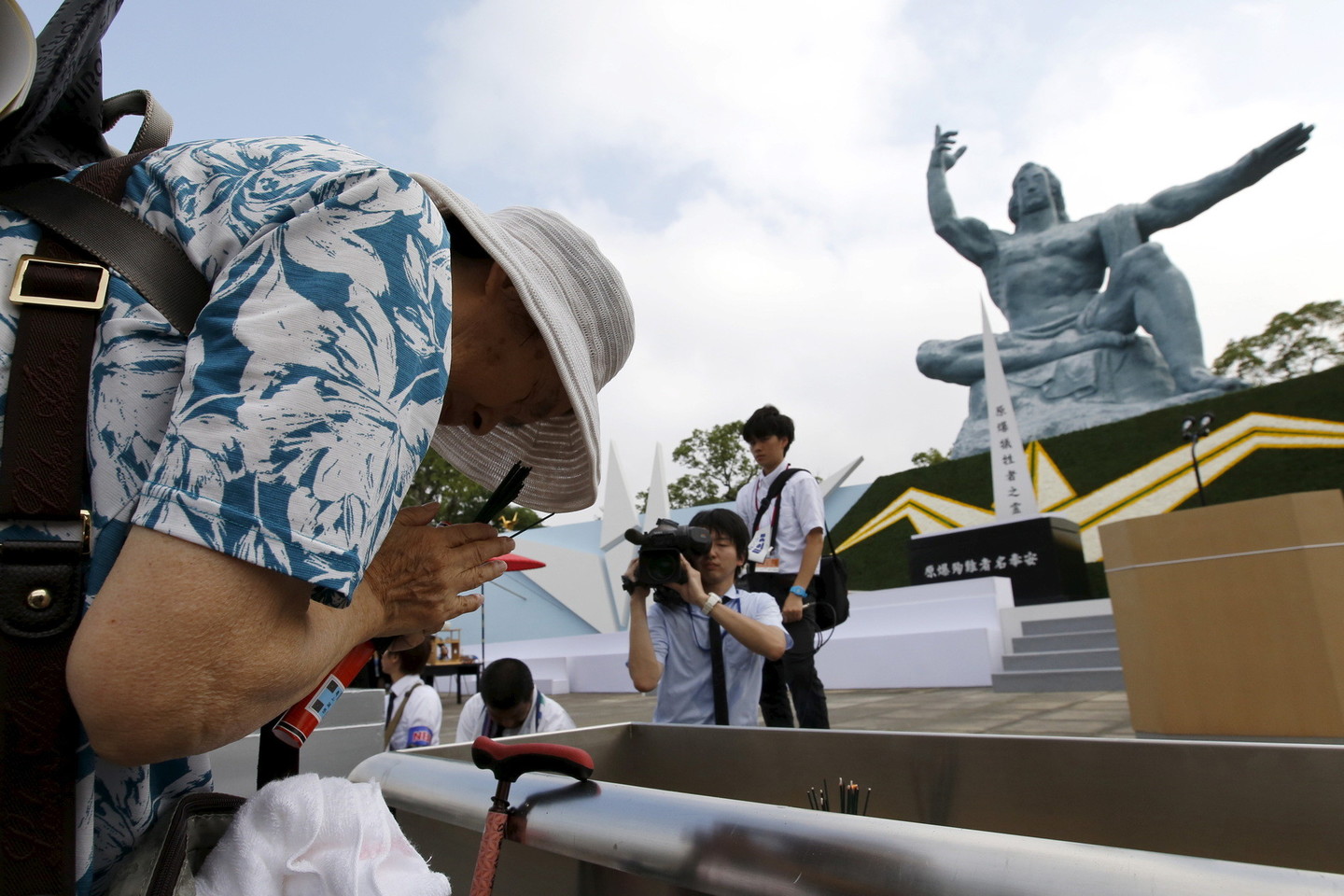 Žmonės meldžiasi Nagasakio taikos parke.<br>„Reuters“/ „Scanpix“ nuotr.