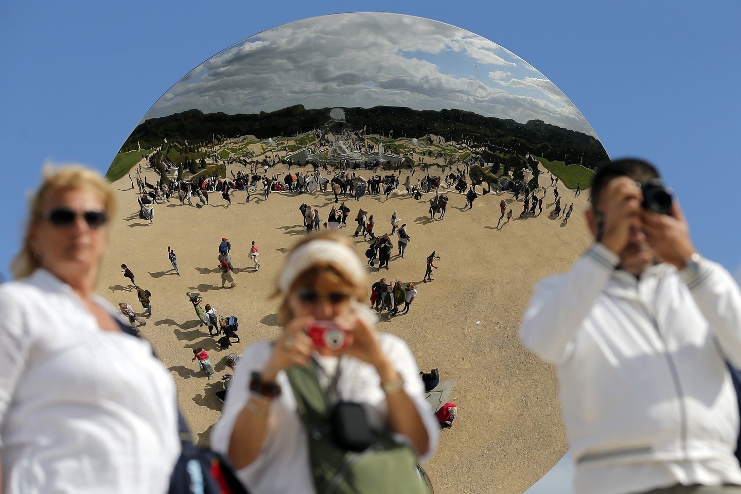 Prie Versalio rūmų eksponuojamas kitas Anisho Kapooro kūrinys „Dangaus veidrodis“ žavi tik turistus, bet ne vandalus.<br>AP nuotr.