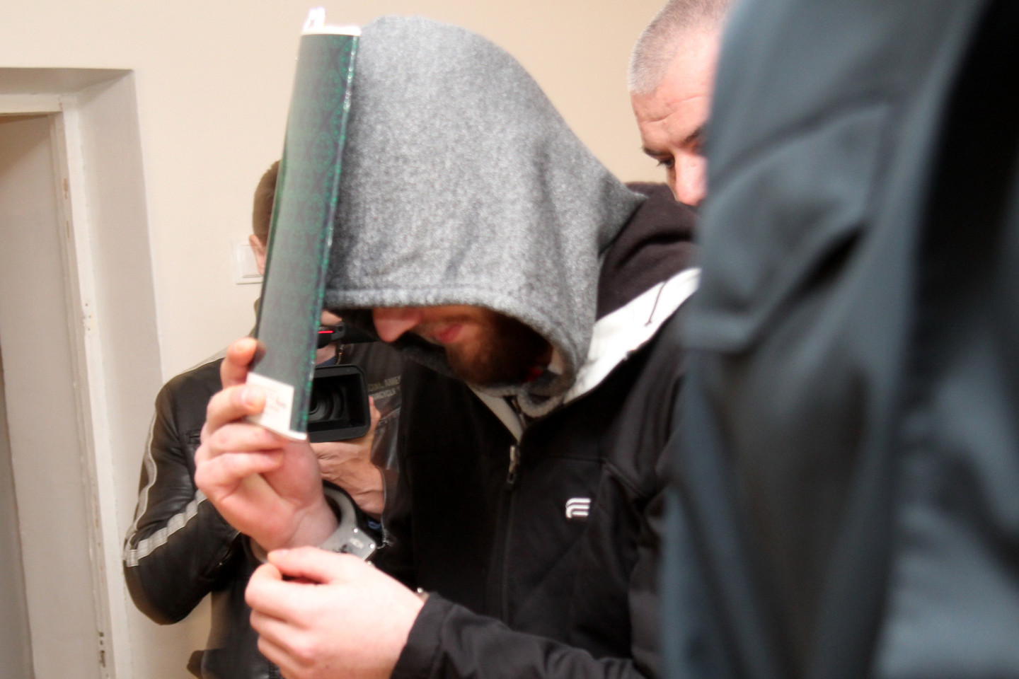 Dviejų žmonių nužudymu kaltinamas Š.Žemaitis teisme slėpė veidą.<br>R.Vitkaus nuotr.