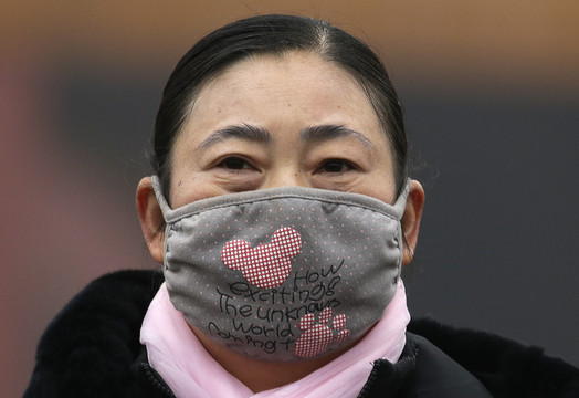 Pekino gyventojai nuo smogo saugosi spalvingomis orą filtruojančiomis kaukėmis.<br>AP nuotr.
