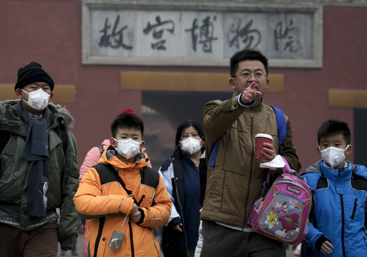 Pekino gyventojai nuo smogo saugosi spalvingomis orą filtruojančiomis kaukėmis.<br>AP nuotr.