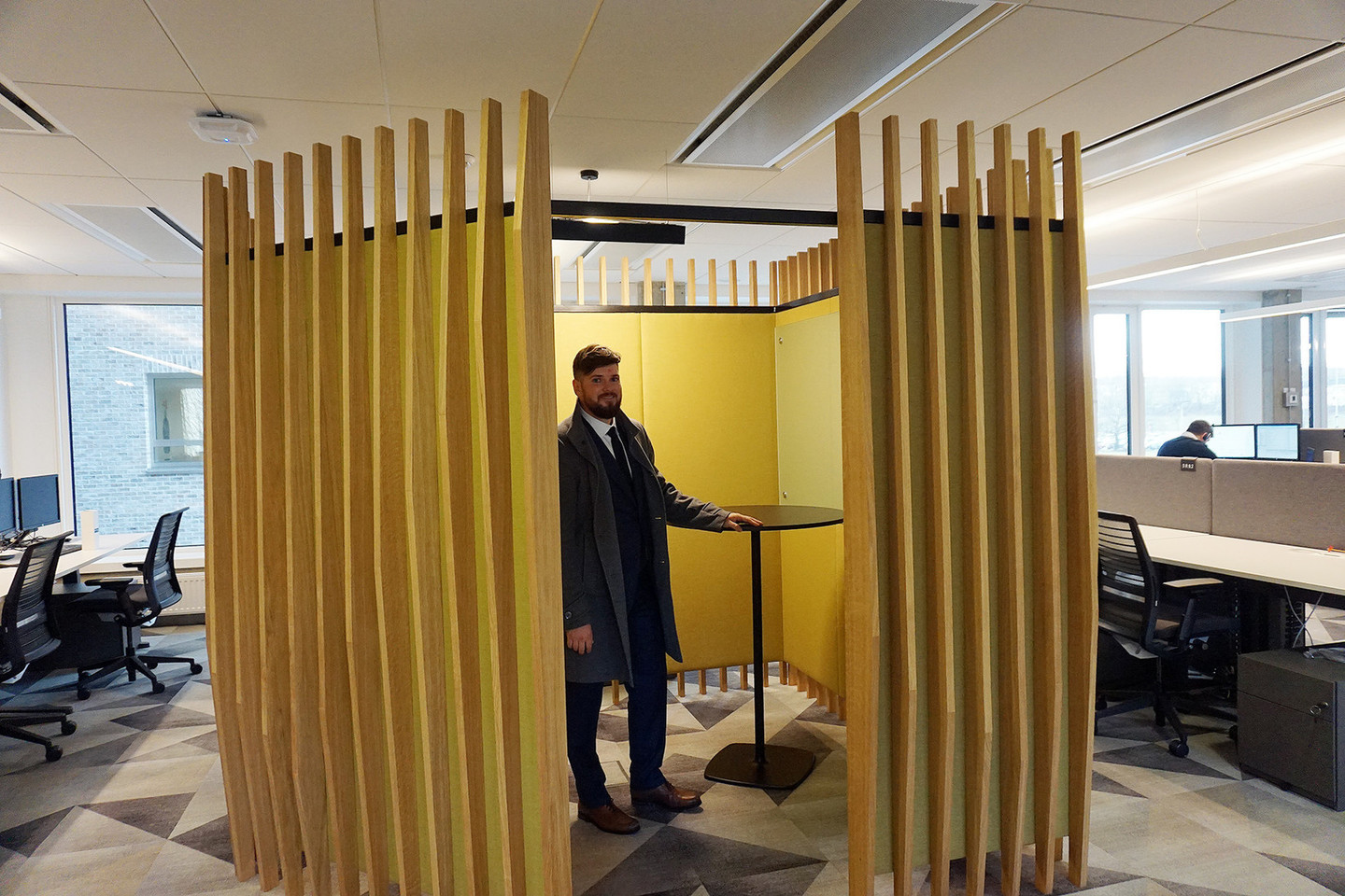 Nerijus Petrauskas demonstruoja, kaip naudotis darbo salėje įrengtu ramybės ar telefoninių pokalbių kambarėliu su garso izoliacija.<br>A.Lukošiaus nuotr.
