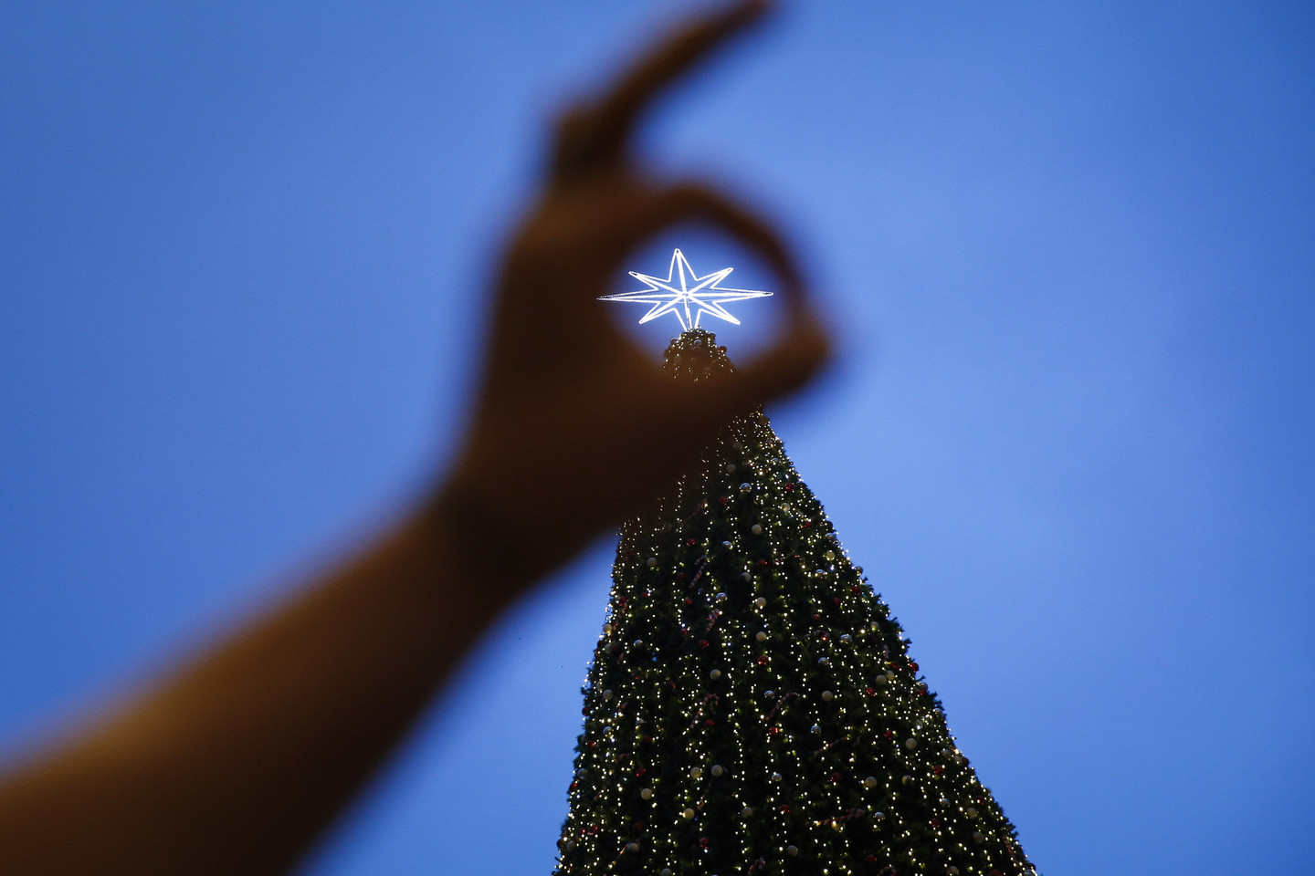 Net jei didžioji gyventojų dalis Kalėdų nešvenčia, daugybė jų fotografuojasi prie dekoracijų ir puošmenų.<br>AP nuotr.