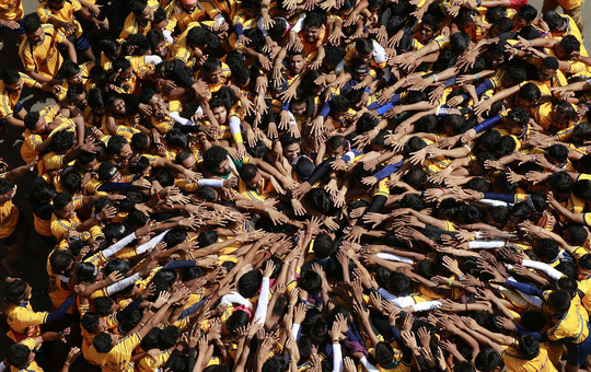 Indų jaunuoliai formuoja žmonių piramidę, kad sudaužytų „Dahi handi“ – varškės kupiną molinį puodą. Taip jie mini „Janmashtami“ festivalį.<br>AP nuotr.
