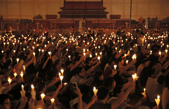 Honkongo Viktorijos parke tūkstančiai žmonių laikė degančias žvakes minėdami 1989 metais studentų vykdytus protestus Tiananmeno aikštėje.<br>AP nuotr.