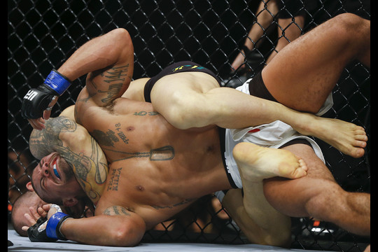 Gleisonas Tibau iš Brazilijos smaugia amerikietį Abelį Trujillo per „Ultimate Fighting Championship“ (UFC) dvikovą San Paule.<br>AP nuotr.