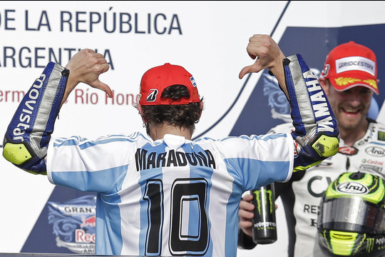 Italas Valentino Rossi Argentinoje laimėjo „MotoGP“ etapą ir pasirodė su Argentinos futbolo dievo Diego Maradonos marškinėliais.<br>AP nuotr.