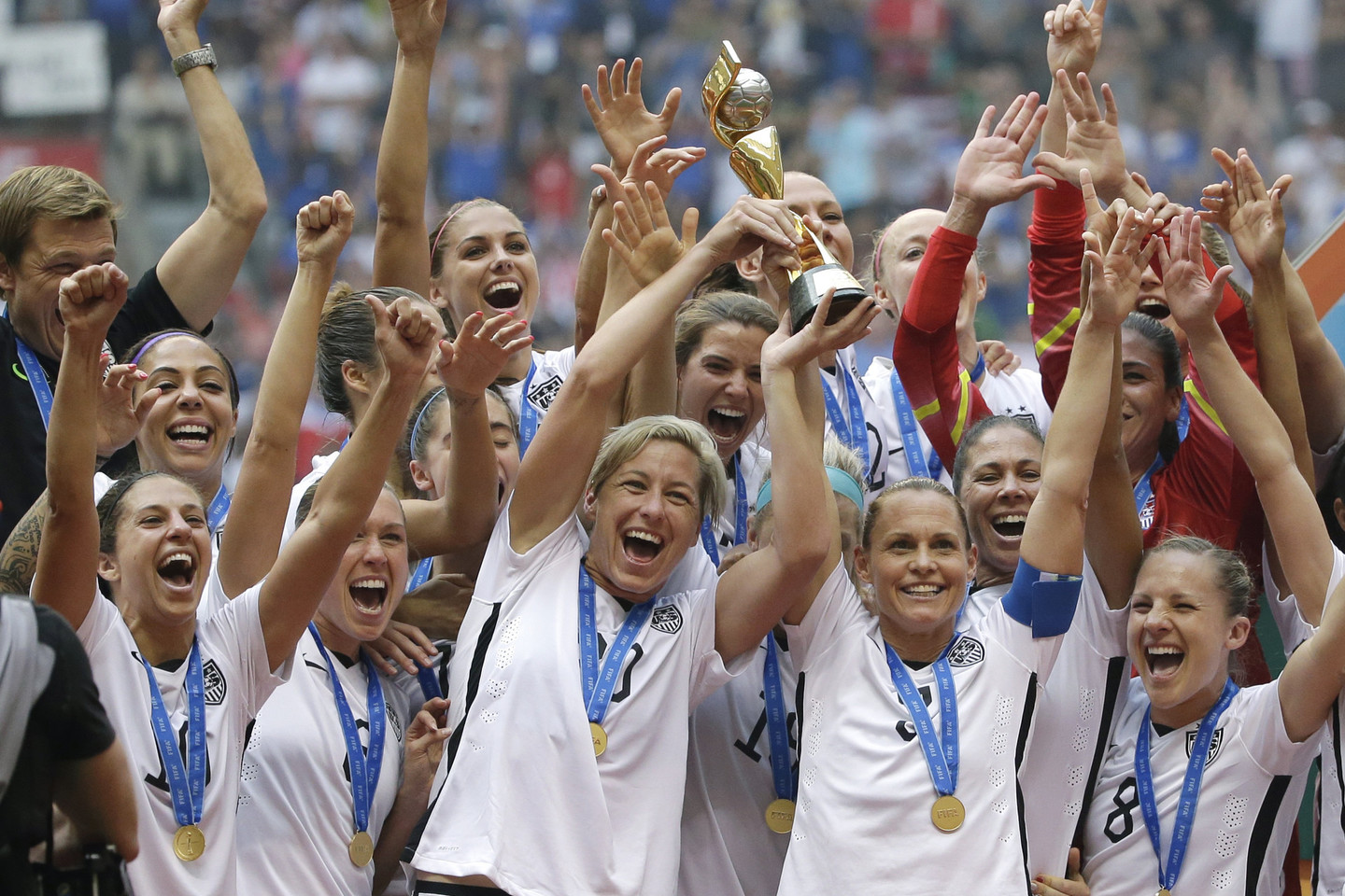 JAV moterų rinktinė džiaugiasi pergale prieš Japoniją ir iškovotu pasaulio čempionato trofėjumi.<br>AP nuotr.