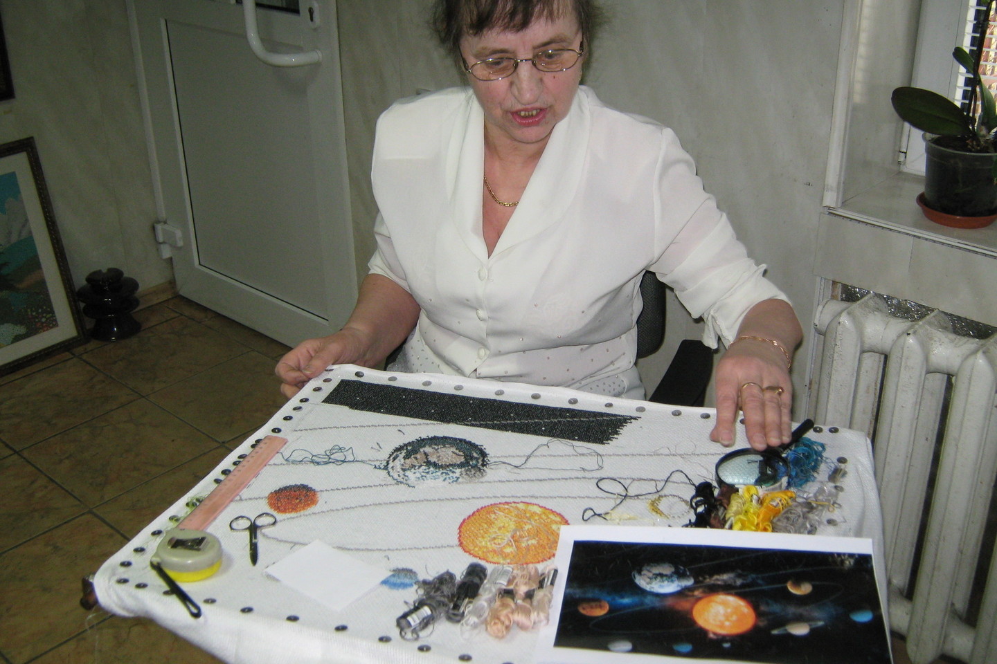 Vilkaviškietė A.Virbickienė šiuo metu siuvinėja kosmoso vaizdą, kurį drobėje padidina keturis kartus.<br>L.Juodzevičienės nuotr.