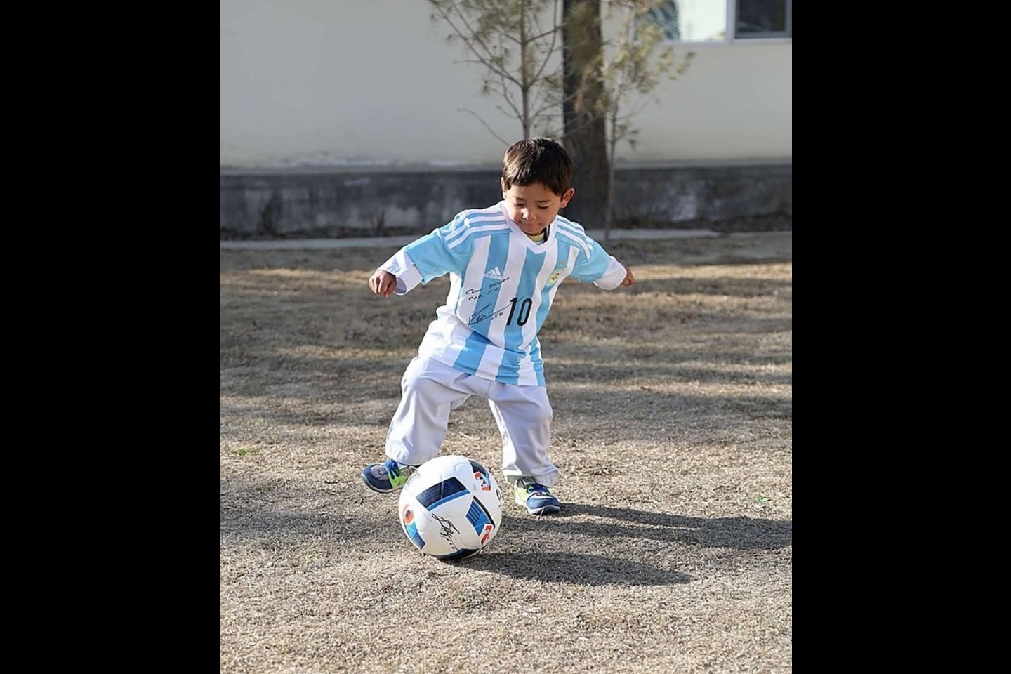 Penkiametis M.Ahmadi iš myliaumiausio futbolininko L.Messi dovanų gavo marškinėlius su parašu ir futbolo kamuolį<br>AFP/“Scanpix“ nuotr.