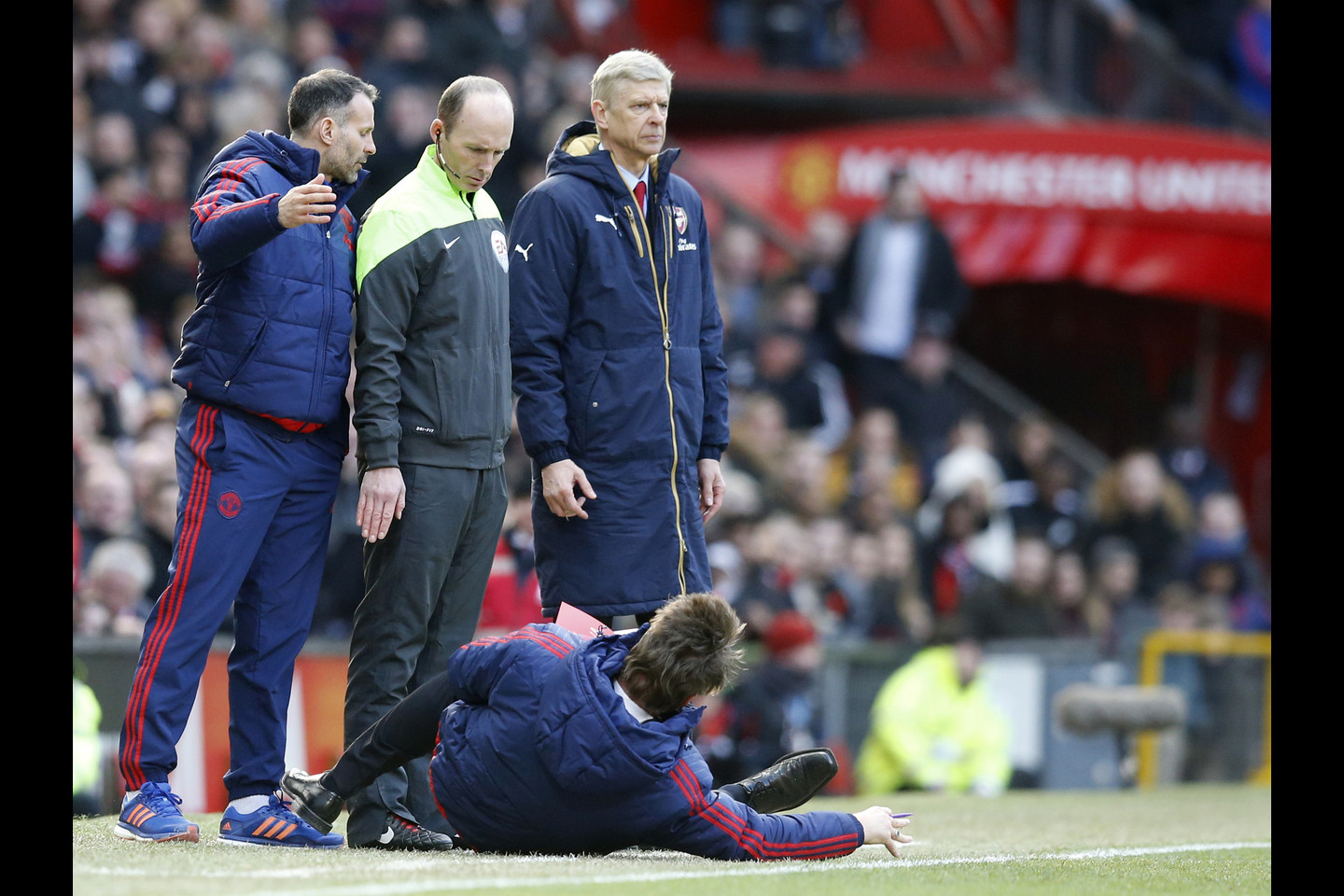 „Manchester United“ treneris Louisas van Gaalas pasivoliojo ant žolės, norėdamas atkreipti dėmesį į nepalankų arbitro sprendimą.<br>AP nuotr.