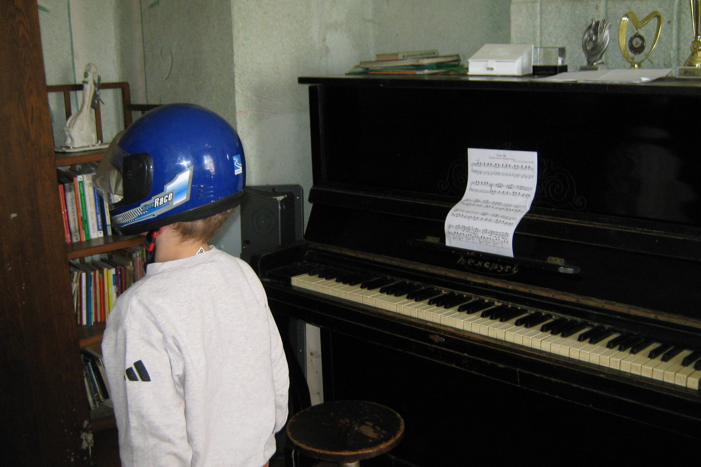 Lukšių namuose keliasdešimties metų senumo pianinu skambina muzikai gabios dukros. Mažiausias – septynmetis – gausioss šeimos narys atvykusiems žurnalistams pademonstravo savo šalmą.<br>L.Juodzevičienės nuotr.